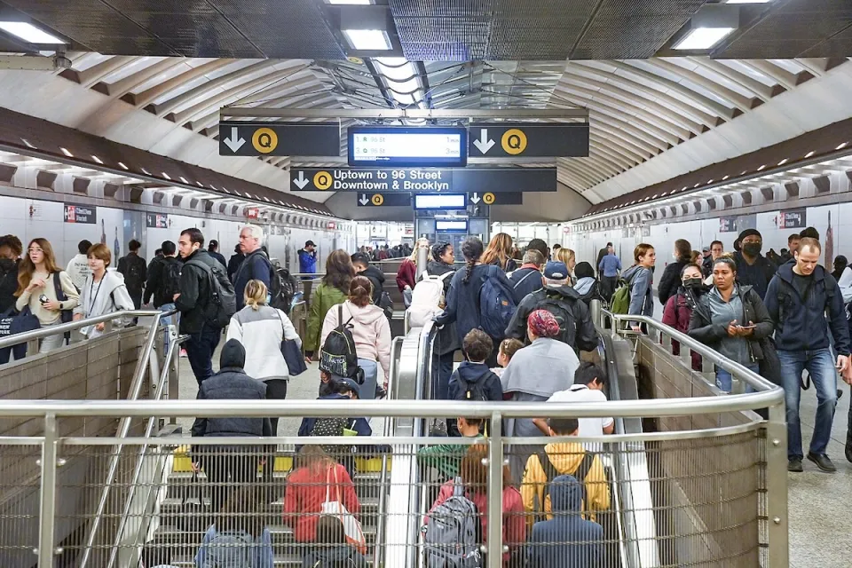 Crowded stairwell in New York City subway station.